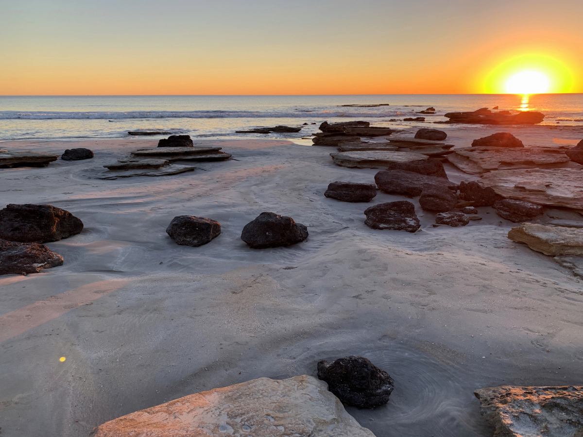 sunset over rocks and ocean cable beach broome