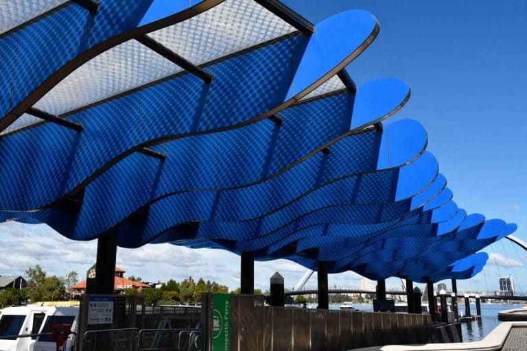 blue sail like sculpture on top of ferry terminal
