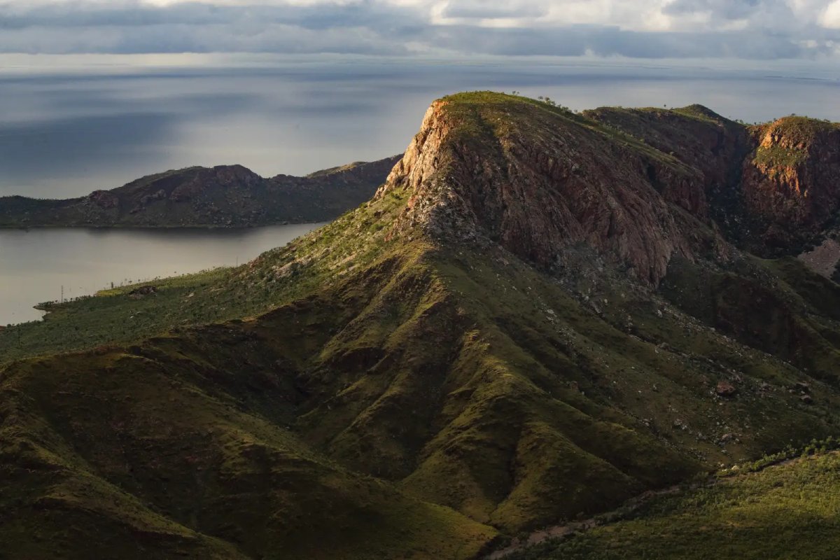 huge hills covered in green grass rising above a huge lake