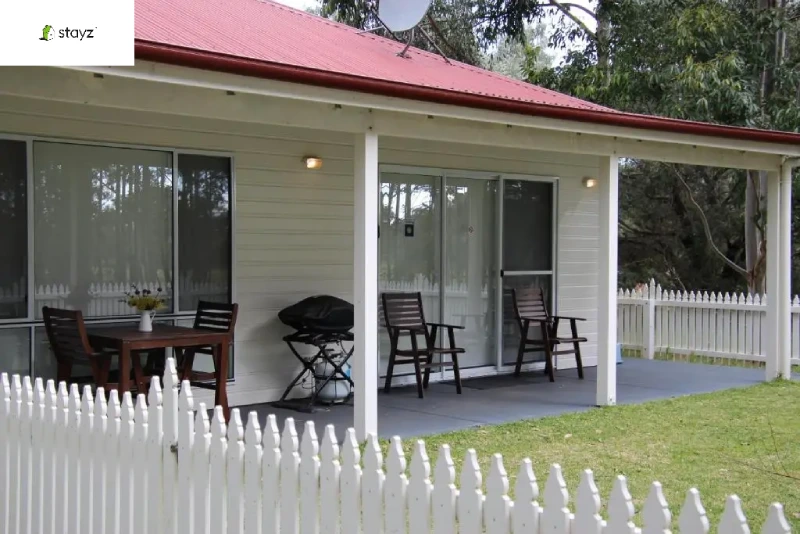 white house with white wooden fence around garden