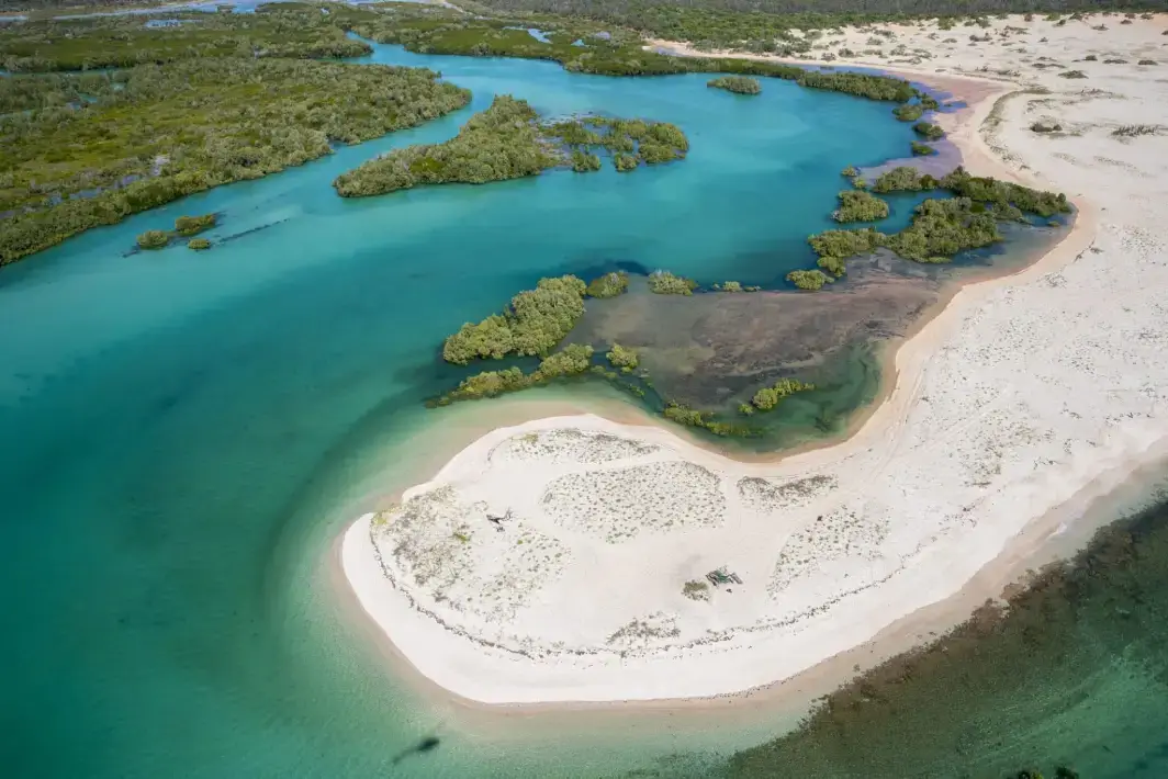 aerial view from helicopter of cygnet bay with white sand and green coloured water