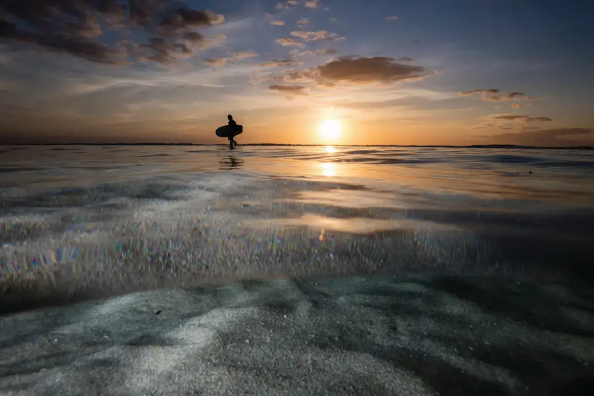 surfer enterting the water at Smiths Beach at sunset margaret river