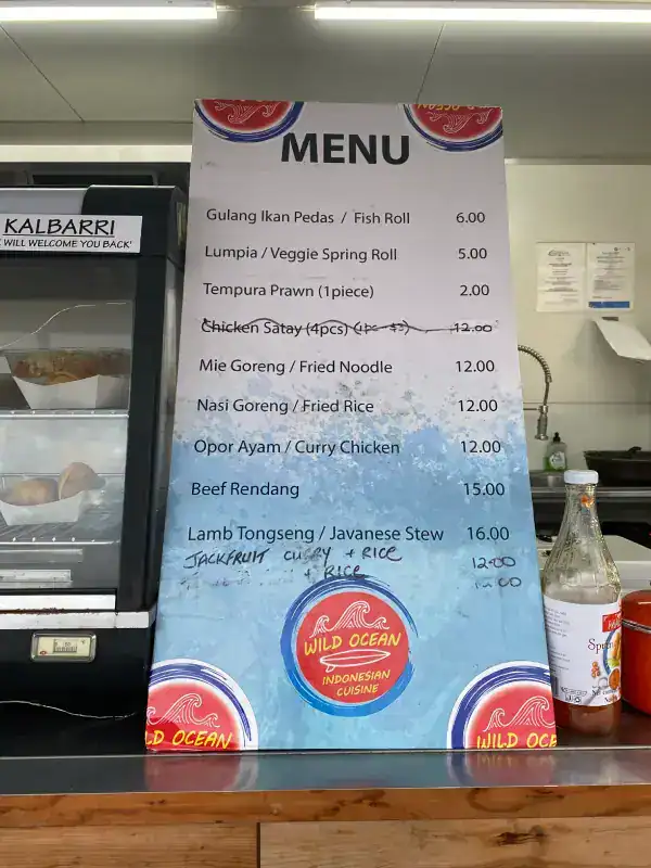 The Best Kalbarri Restaurants, Bars, and Cafes: My Guide for 2026 20 A menu board for Wild Ocean Indonesian Cuisine, listing dishes such as Fish Roll, Lumpia, Tempura Prawn, Chicken Satay, Mie Goreng, and Beef Rendang, along with prices.